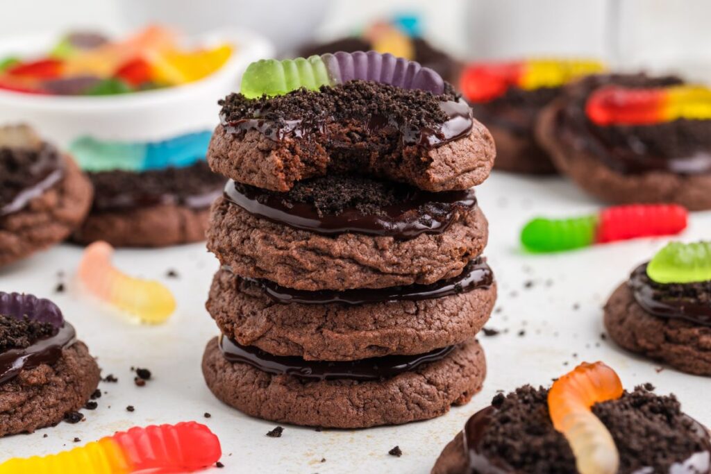 Stack of dirt and worm cookies with bite missing from the top cookie.