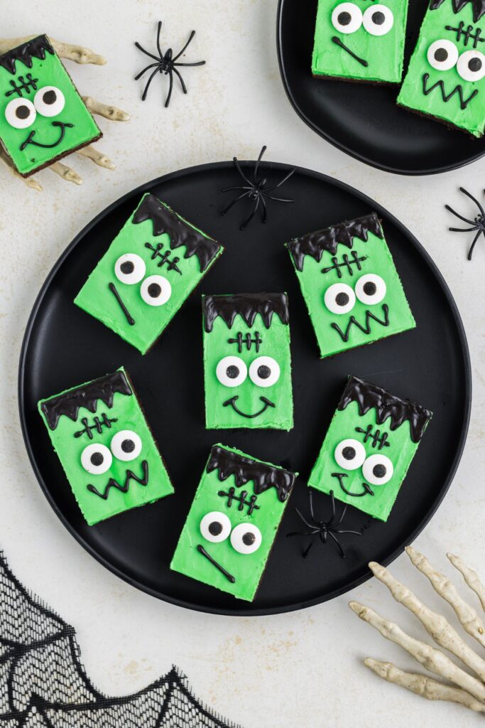 Plate of green Frankenstein cookie bars with candy eyes.