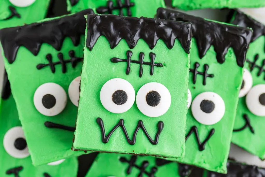 Pile of Frankenstein cake mix cookie bars with green buttercream.