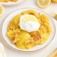 3-Ingredient lemon dump cake topped with whipped cream.