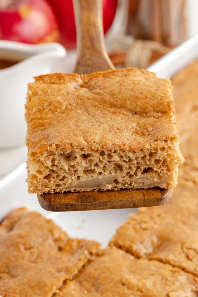 Slice of apple cake being removed from the pan.