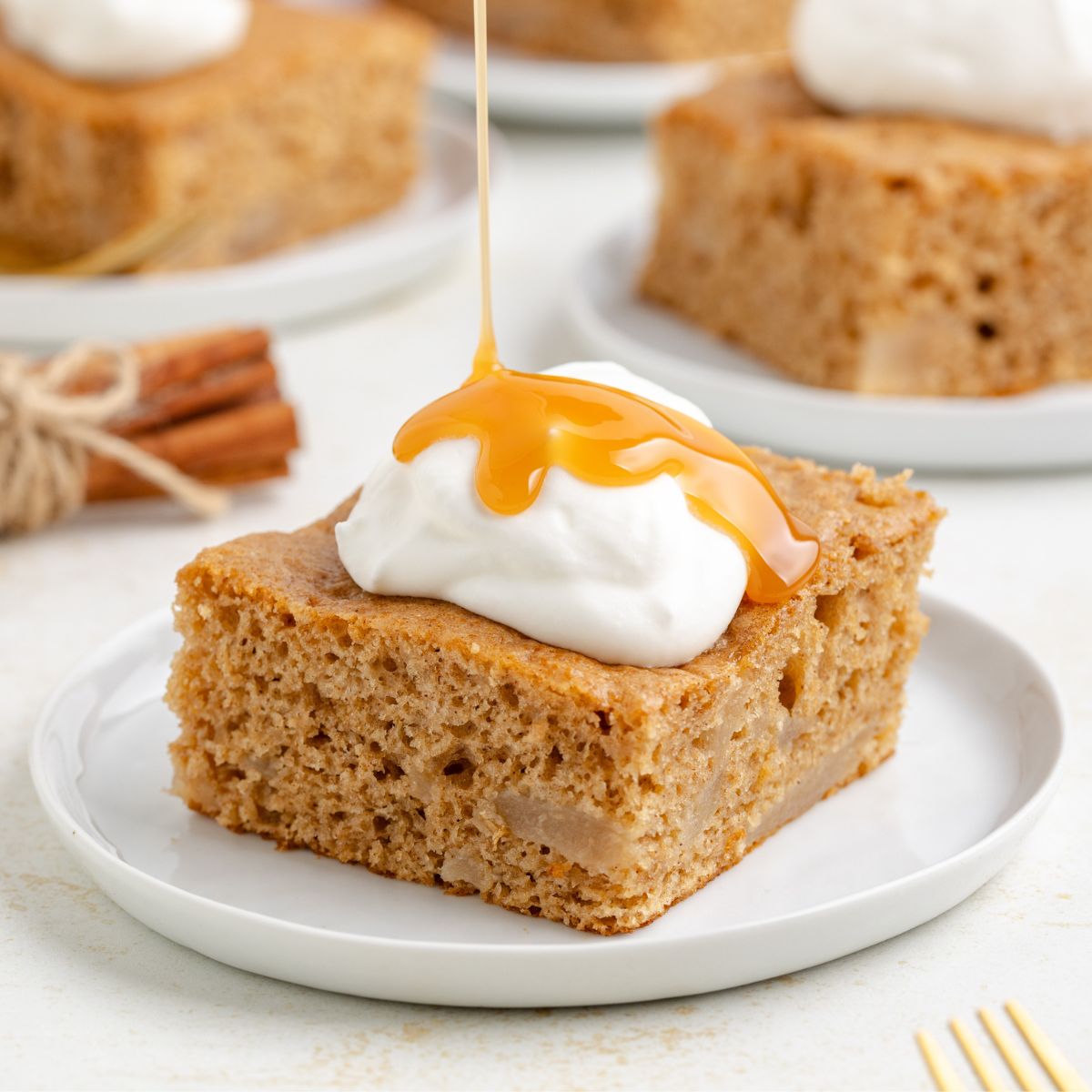 3 ingredient apple cake topped with whipped cream and caramel sauce.