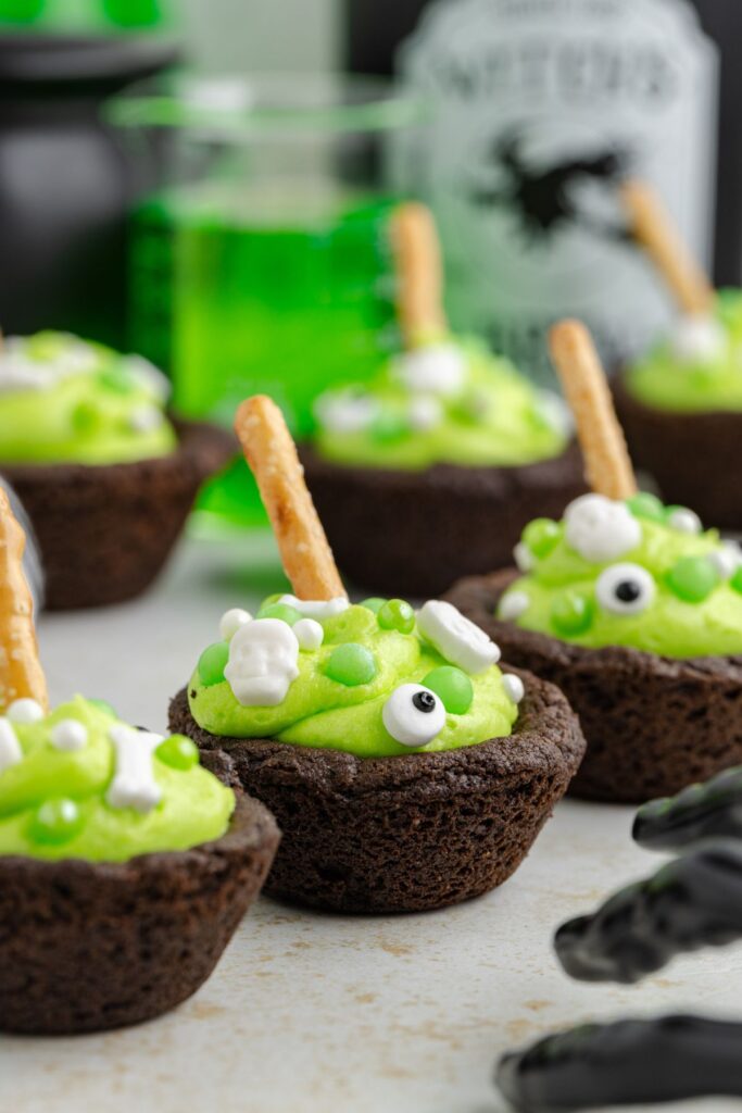 Three cookie cups decorated like witches cauldrons.