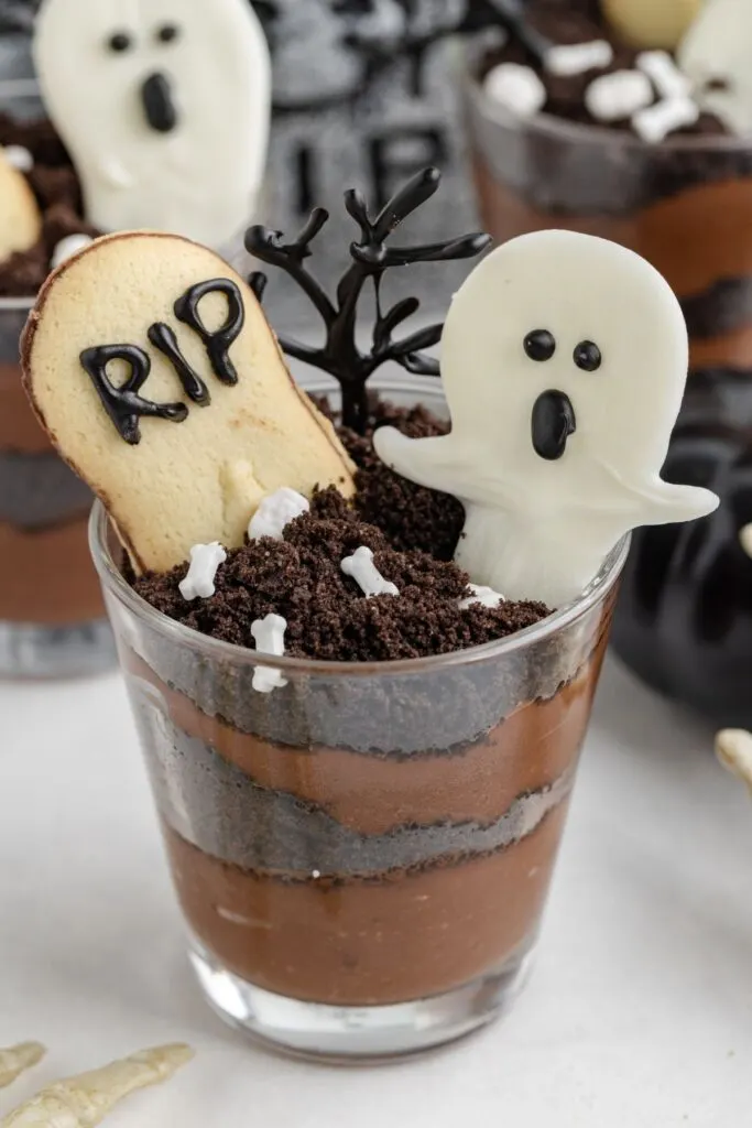 Chocolate pudding dirt cups decorated as graveyards.