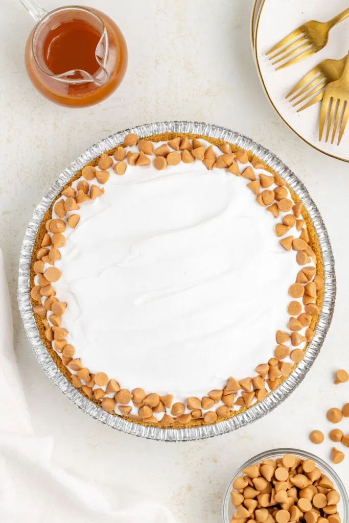 Butterscotch pie topped with Cool Whip and butterscotch chips.