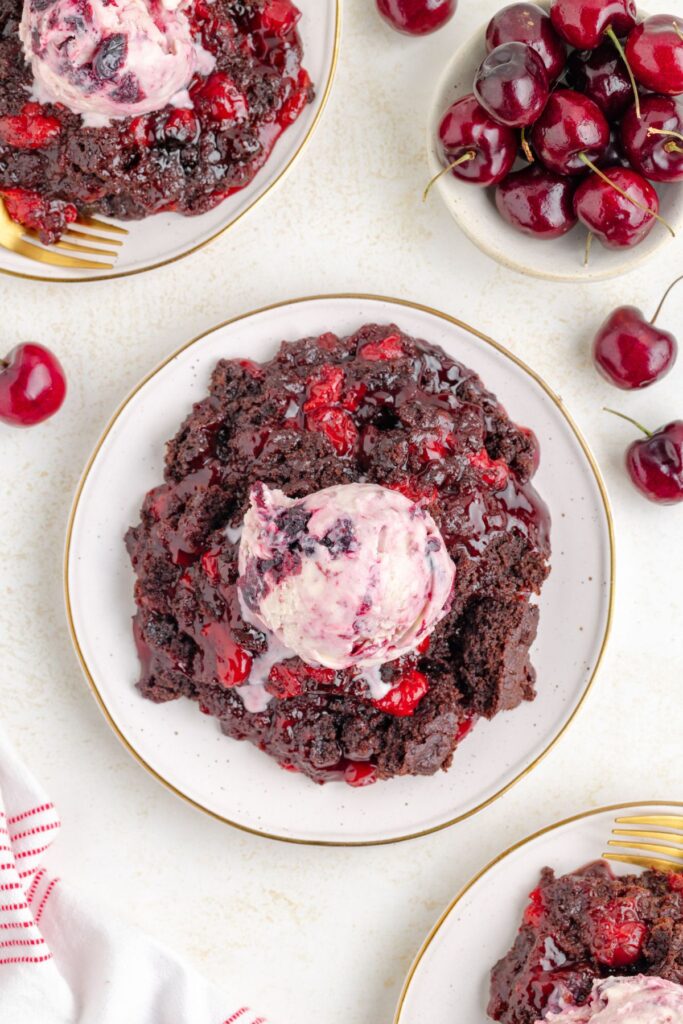 Slow Cooker Chocolate Cherry Dump Cake topped with cherry ice cream.