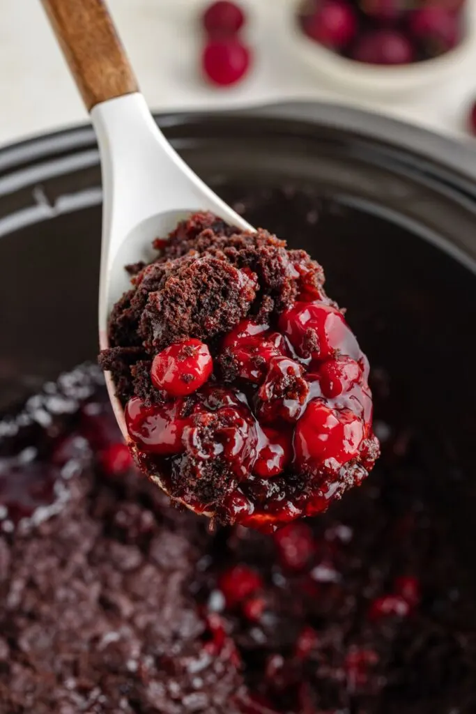 Scoop of crockpot chocolate cherry dump cake.