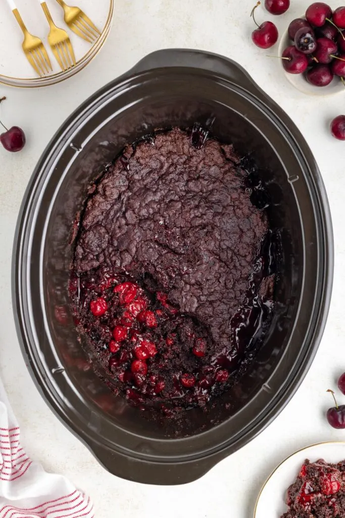 Crockpot chocolate cherry cake with scoop missing.