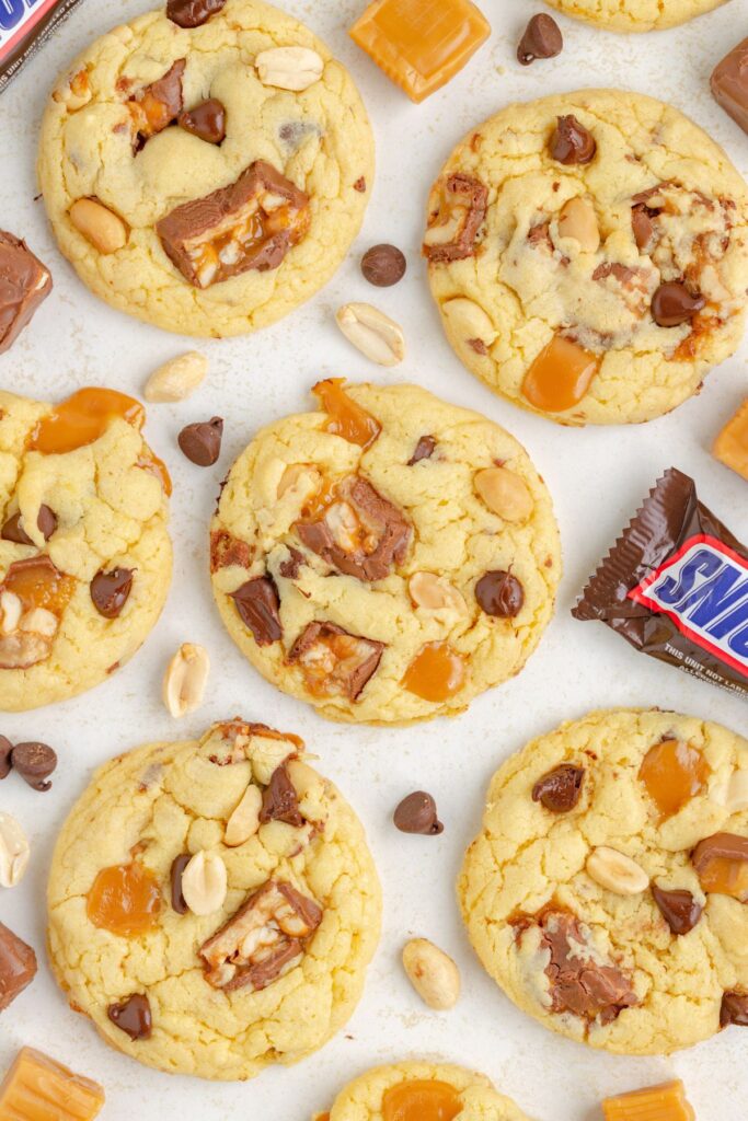 Snickers cake mix cookies with caramels, chocolate chips, and peanuts.