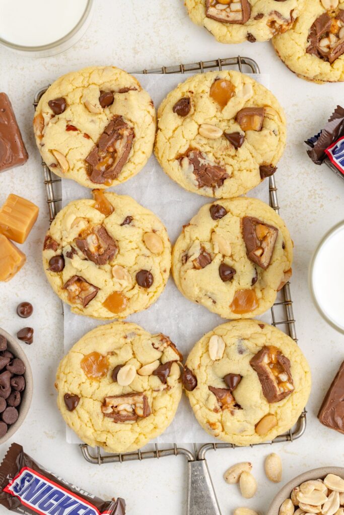 Six cake mix Snickers cookies on a cooling rack.