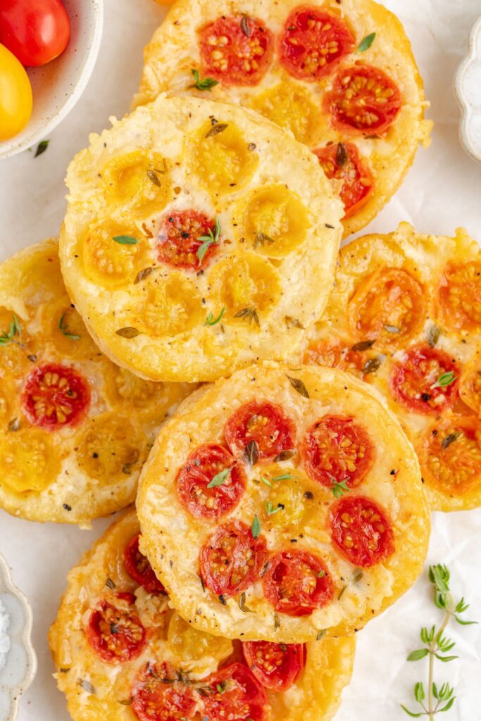 Pile of Tomato Upside Down Puff Pastry Tarts with gruyere cheese.