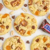 Snickers cake mix cookies with caramels, chocolate chips, and peanuts.