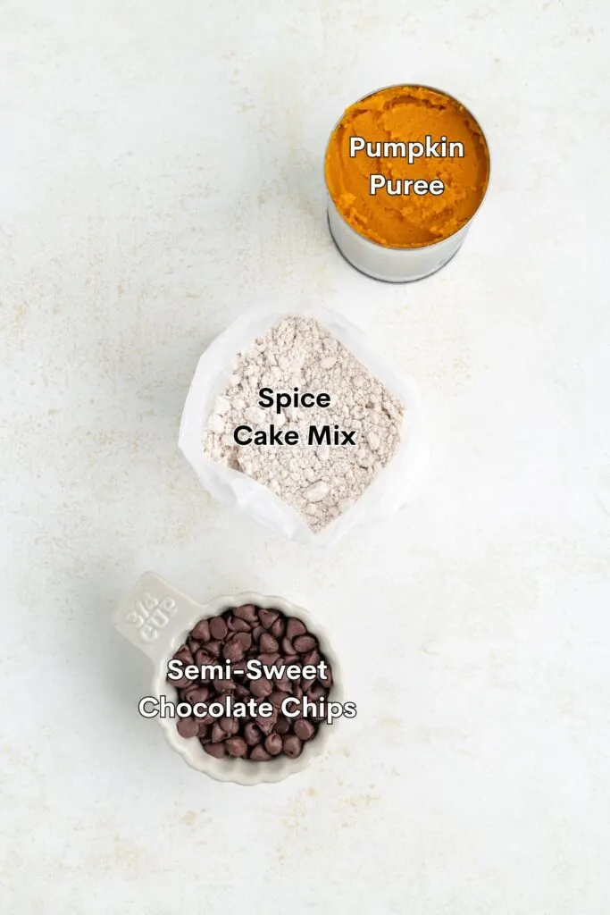 Ingredients such as spice cake mix, pumpkin puree, and chocolate chips displayed on the counter. 