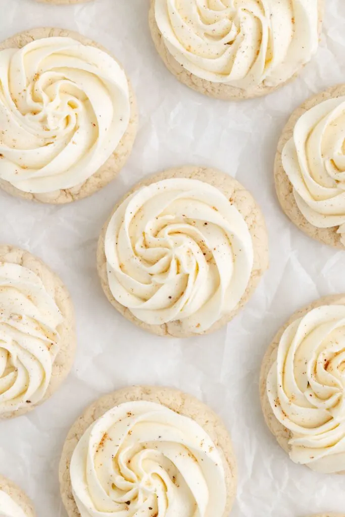 Cake mix eggnog cookies with piped buttercream arranged on the counter.