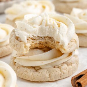 Frosted eggnog cake mix cookies with eggnog buttercream with a bite missing.