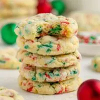 Stack of four gooey butter Christmas cookies with a bite missing from the top cookie.