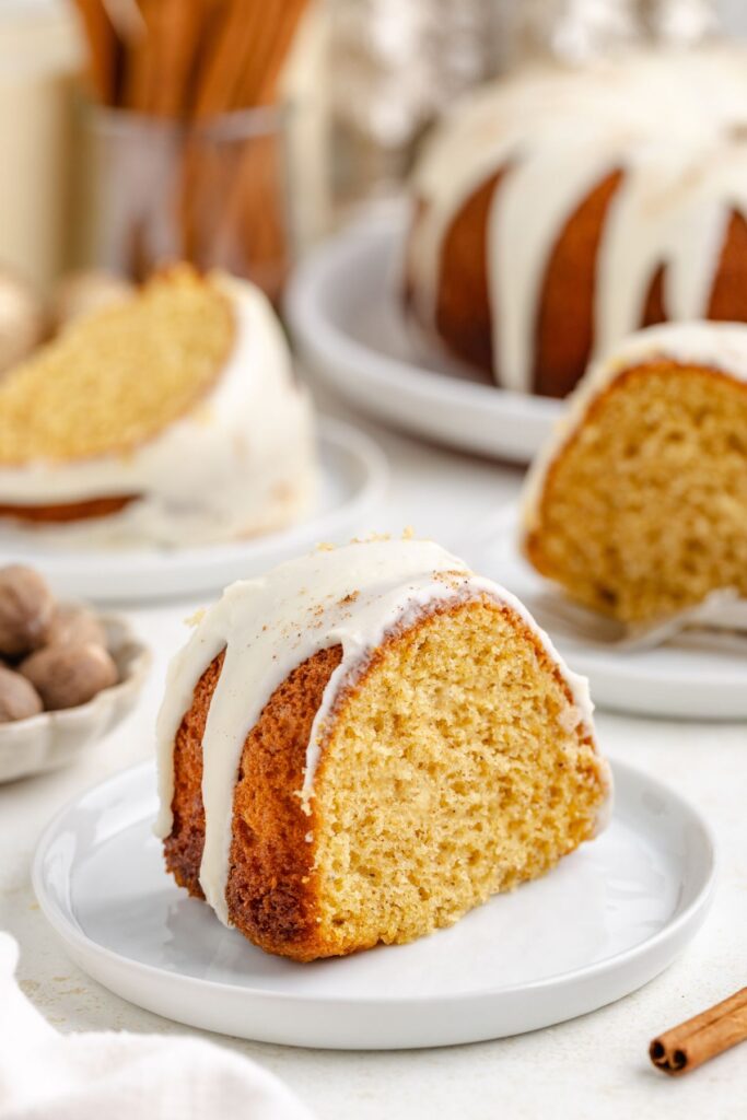 Slice of eggnog bundt cake with glaze on a small plate.