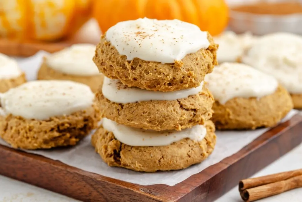 Stack of cream cheese frosted pumpkin cookies made from cake mix.