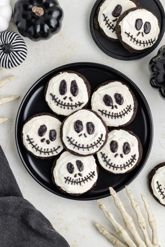 Black plate full of chocolate cake mix cookies decorated like Jack Skellington.