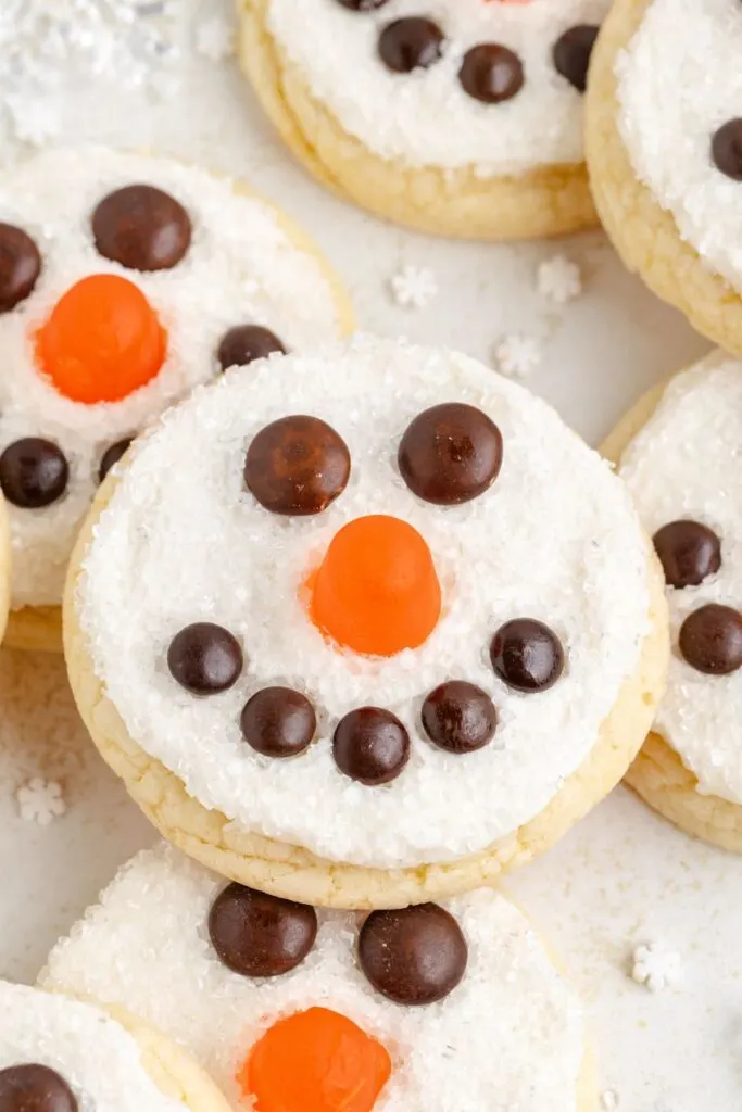 Snowman face cookies with candy nose and M&M eyes and mouth.