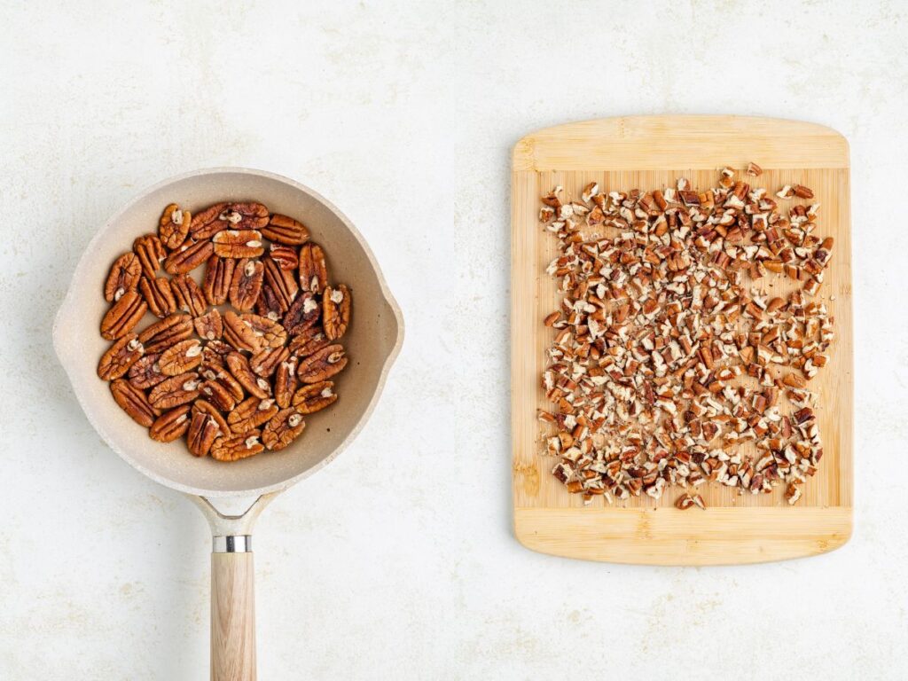 A saucepan with whole pecans on the left and a wooden cutting board with chopped pecans on the right, all placed on a light textured surface.