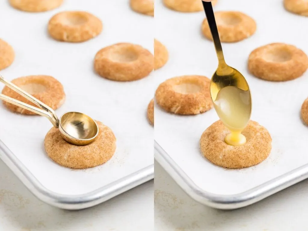 Two images side by side: The left shows a spoon pressing into a baked cookie on a tray, creating an indentation. The right shows a spoon pouring a creamy filling into the cookie indentation. Both cookies are on a parchment-lined baking sheet.