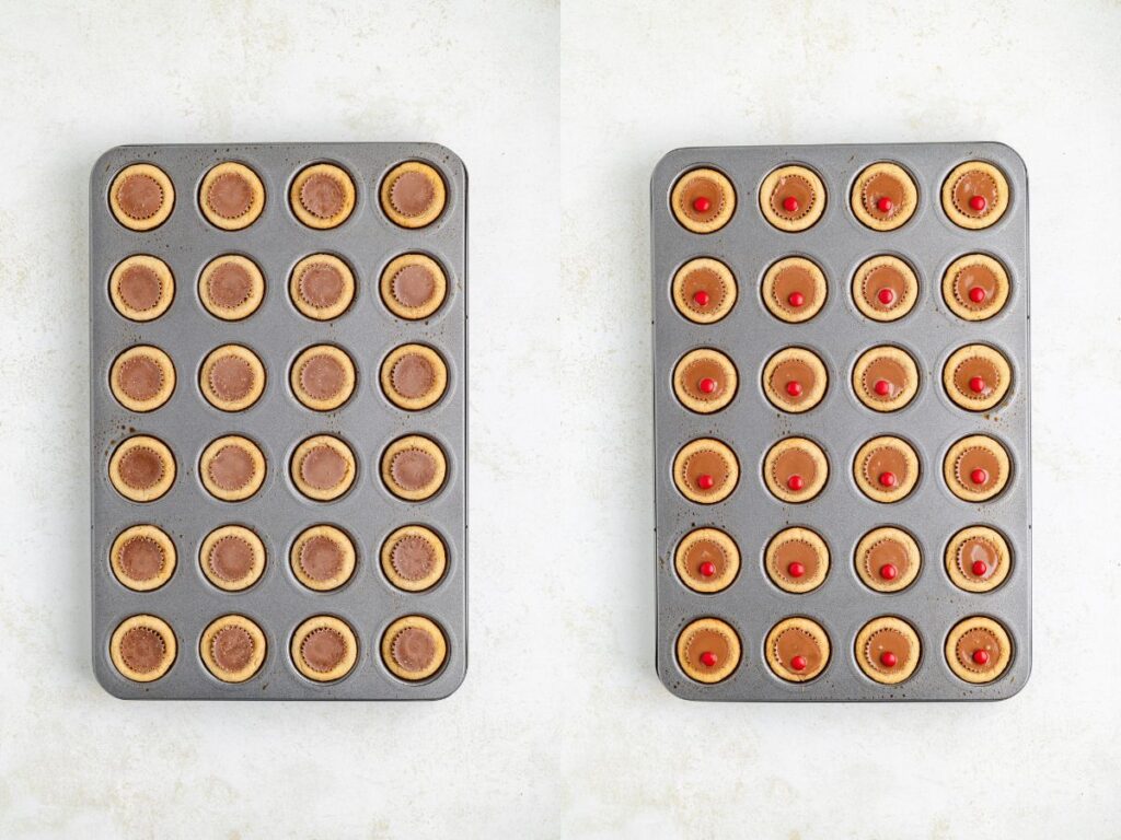 Two side-by-side muffin trays filled with tarts. The left tray has baked chocolate tarts with smooth tops. The right tray also has baked tarts, each topped with a small red candy at the center. The trays are on a lightly textured surface.