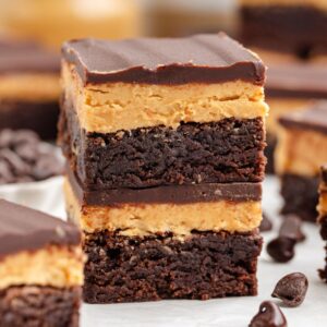 Two stacked Buckeye Brownies, with peanut butter frosting and chocolate ganache layers.