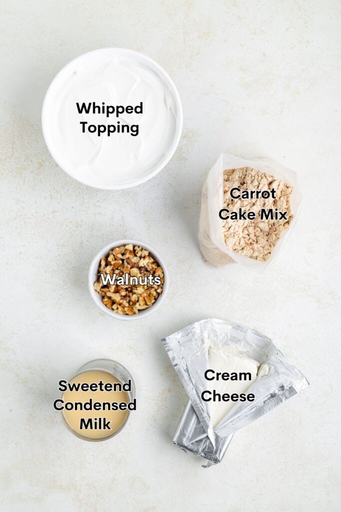 Carrot Poke Cake ingredients: carrot cake mix, whipped topping, walnuts, condensed milk, and cream cheese packets.