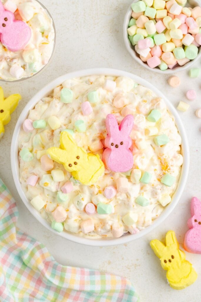 Easter-themed marshmallow salad topped with pink and yellow bunny-shaped candies, surrounded by pastel marshmallows.