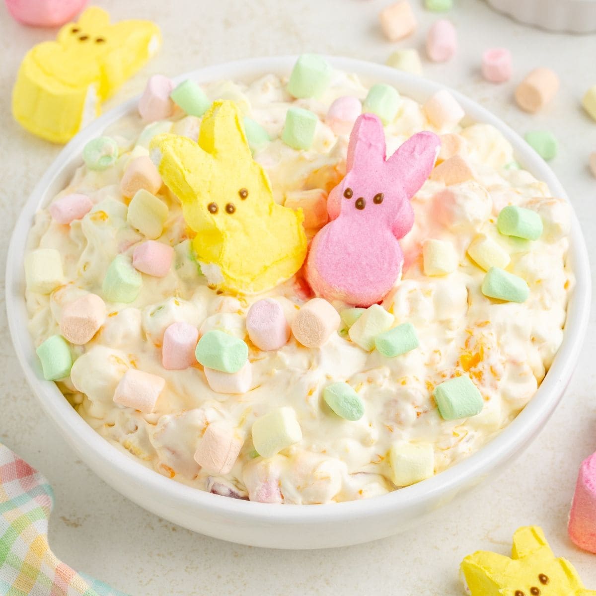 Bowl of marshmallow salad topped with colorful mini marshmallows and two cute marshmallow chicks for Easter.