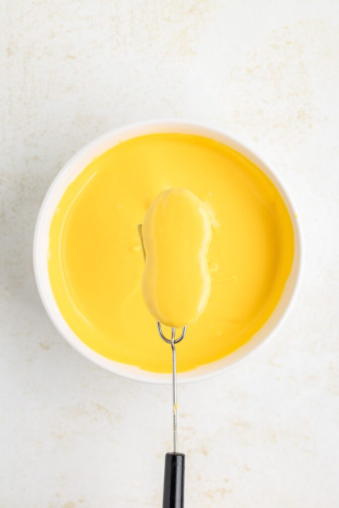 Nutter butter cookie dipped in melted yellow chocolate.
