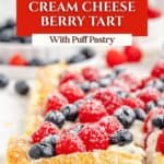 Berry Puff Pastry Tart with cream cheese, blueberries, raspberries, and powdered sugar; bowl of berries behind.