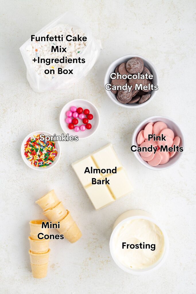 Dessert ingredients: cake mix, candy melts, sprinkles, almond bark, mini cones, and frosting on white background.