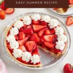 Strawberry jello pie with whipped cream and fresh strawberries, surrounded by plates, forks, and whole strawberries.