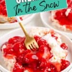 Cherries in the Snow dessert with whipped topping on a plate, served with a gold fork.