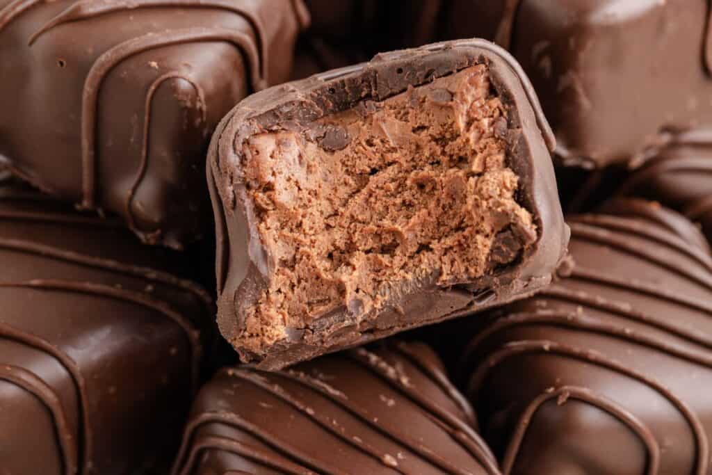 Close-up of chocolate Cool Whip candy, with a center truffle bitten to reveal creamy filling.