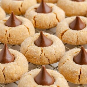 Peanut butter blossom cookies with Hershey’s Kisses on top cooling on a wire rack.