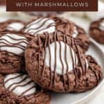 Plate of hot chocolate cookies with marshmallows and chocolate drizzle, labeled Hot Cocoa Cookies from Semi Homemade Kitchen.