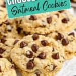 Freshly baked chocolate chip oatmeal cookies on a cooling rack with a sign reading "Chocolate Chip Oatmeal Cookies.