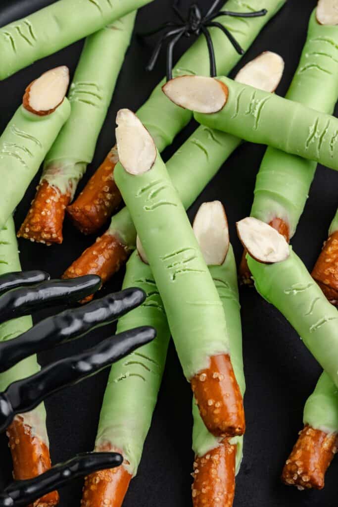 Green candy-coated pretzel witch fingers with almond nails.