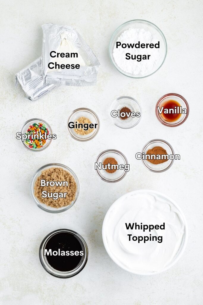 Assorted labeled bowls of cream cheese, whipped topping, sugars, spices, vanilla, molasses, and sprinkles on white surface.