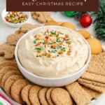 Gingerbread dip with sprinkles in a bowl, surrounded by cookies and graham crackers on a festive table.