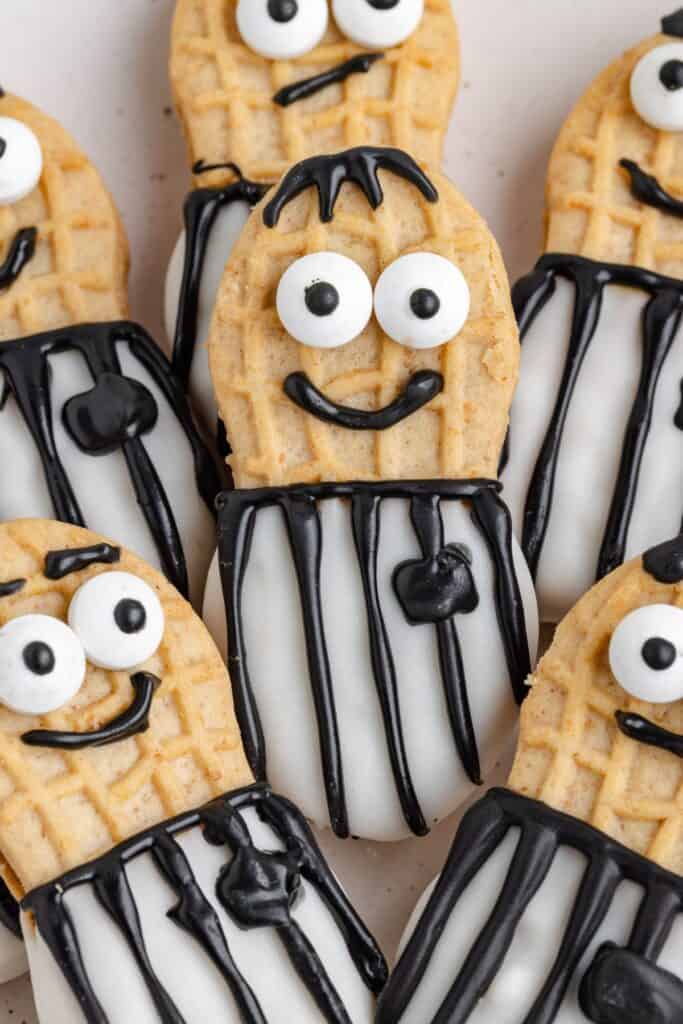 Referee Nutter Butter cookies decorated as smiling and surprised faces wearing striped referee uniforms with icing.