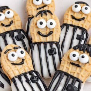 Nutter Butter referee cookies decorated with black and white icing, striped shirts, and expressive faces.