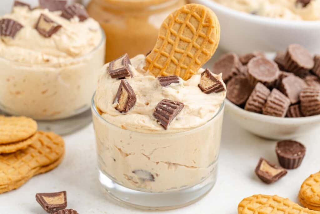 Peanut butter fluff served in a glass, topped with a single cookie.