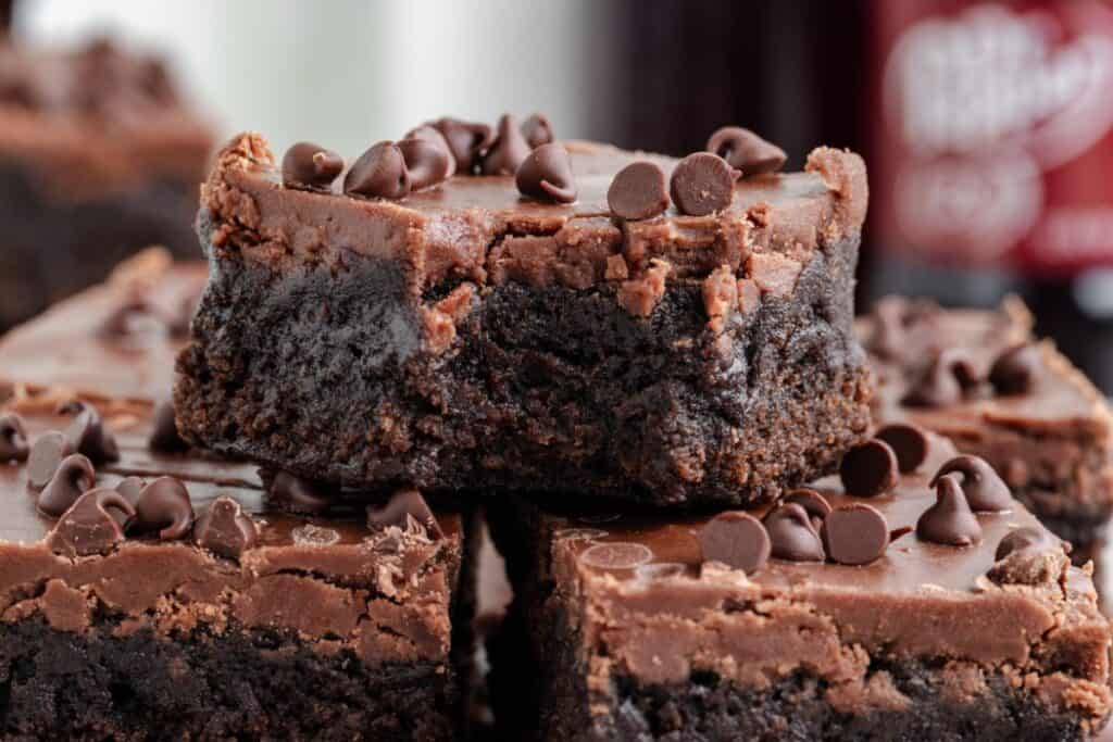 Close-up of stacked Dr Pepper brownies with box mix topped with chocolate chips.