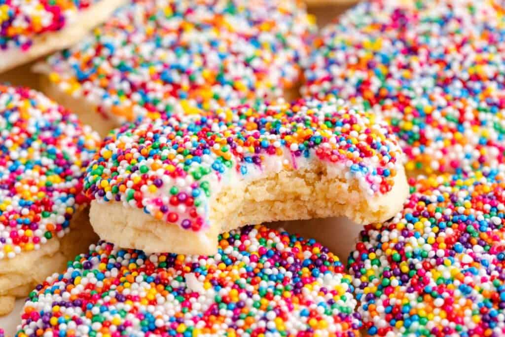 Close-up of cake mix dot cake cookies, one in the center has a bite taken out.