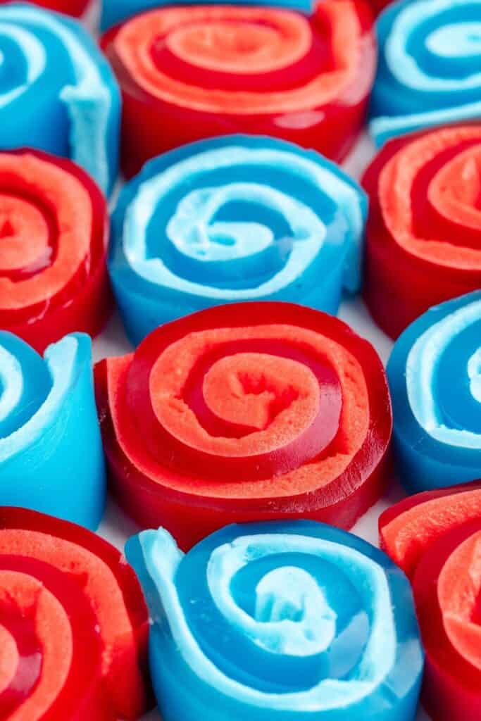 Close-up of neatly arranged red and blue rolled gummy candies.