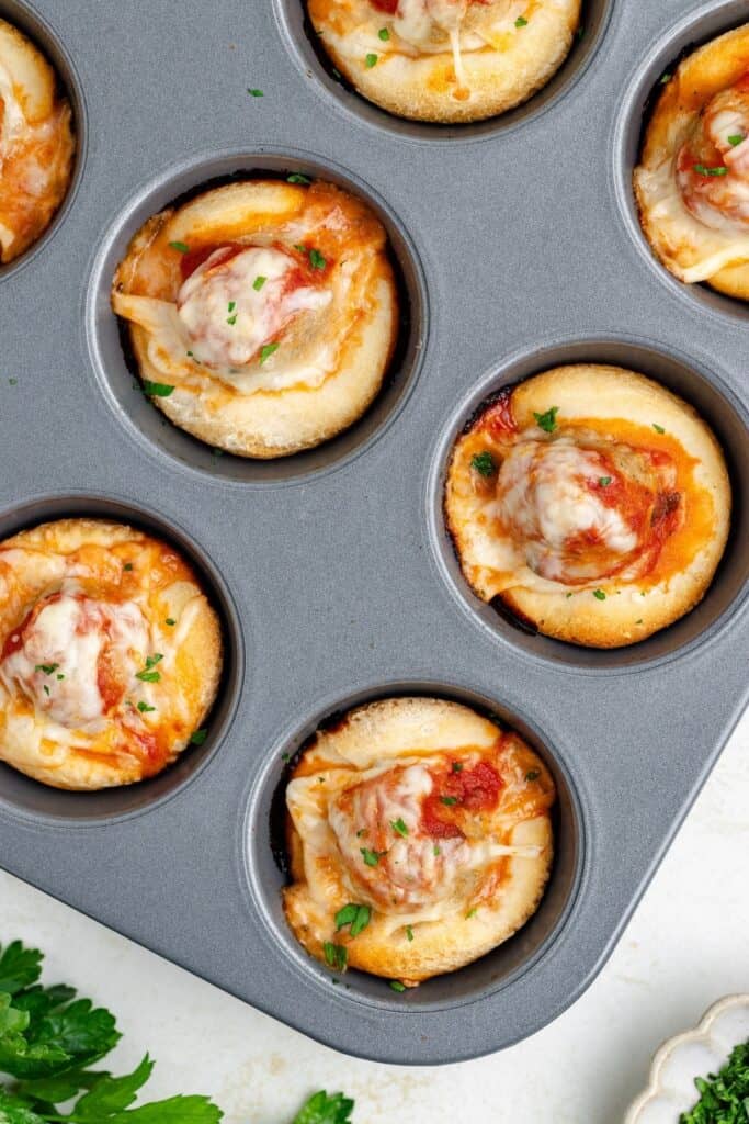 Meatball Biscuit Cups topped with herbs.